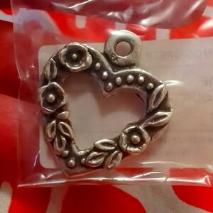 Silver colored metal heart pendant with flowers. For hand crafted artisan work.